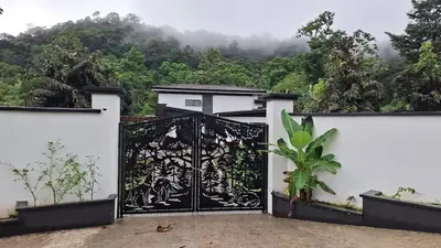 a gate to a house with a mountain in the background at Residential Finca Celeste in Bijagua
