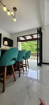 a dining room with green chairs and a table at Residential Finca Celeste in Bijagua