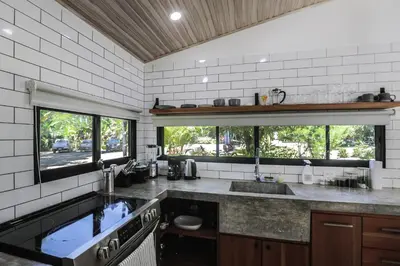 a kitchen with a sink and a large window at The Retreat Uvita in Uvita