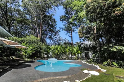 a swimming pool with a fountain in a yard at The Retreat Uvita in Uvita