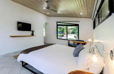a bedroom with a large white bed and a window at The Retreat Uvita in Uvita