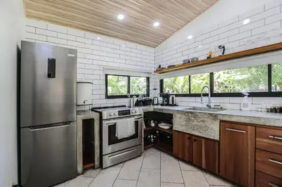 a kitchen with a stainless steel refrigerator and a sink at The Retreat Uvita in Uvita