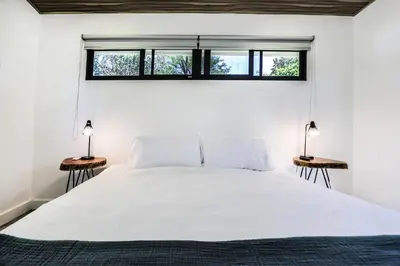 a bedroom with a large white bed with two lamps at The Retreat Uvita in Uvita