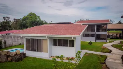 a house with a red roof and a yard at Villa Vet Stylish 3BR Home - New Build - Perfect for families in Fortuna