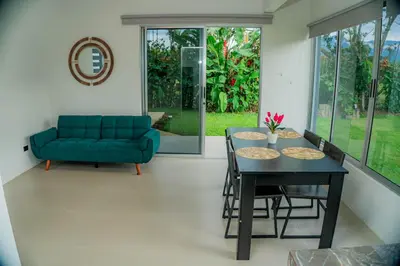 a living room with a couch and a table and chairs at Villa Elemental Modern Villa Volcano Views & Luxe Touches in Fortuna