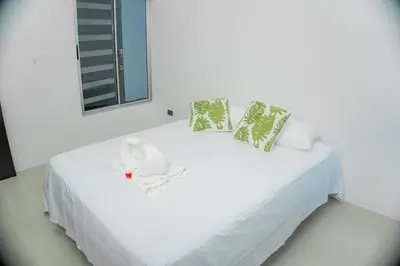 a white bed with a stuffed animal on it at Villa Elemental Modern Villa Volcano Views & Luxe Touches in Fortuna