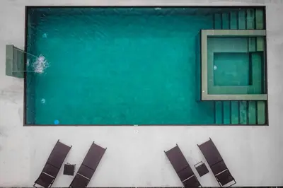 a group of chairs sitting next to a swimming pool at Villa Elemental Modern Villa Volcano Views & Luxe Touches in Fortuna