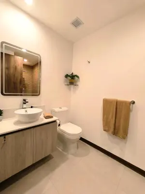 a bathroom with a toilet and a sink and a mirror at Luxury condo in Selva Coral Jacó Beach in Jacó