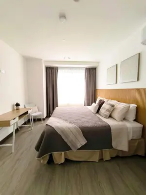 a bedroom with a bed and a desk and a window at Luxury condo in Selva Coral Jacó Beach in Jacó