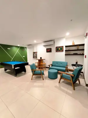 a living room with a ping pong table and chairs at Luxury condo in Selva Coral Jacó Beach in Jacó