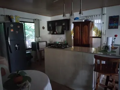 a kitchen with a refrigerator and a counter top at Villa Elena Vacation Home in Nicoya