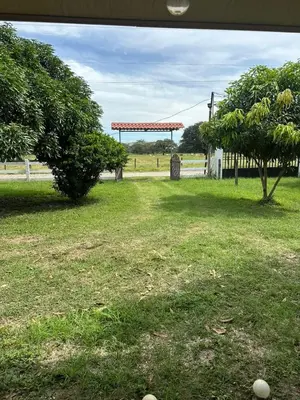 a field with a fence and a tree and a gazebo at Villa Elena Vacation Home in Nicoya