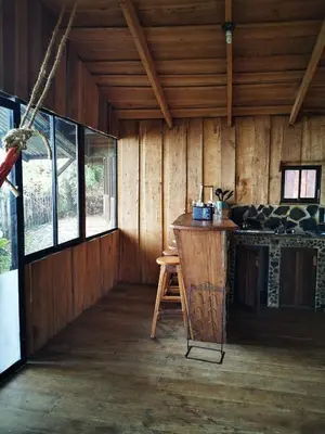 a room with a counter in a wooden cabin at Rio Paquita Lodge in Tapantí