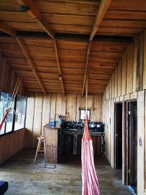 a room with wooden walls and a wooden ceiling at Rio Paquita Lodge in Tapantí