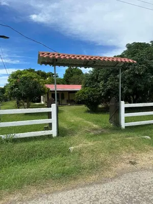 a white fence next to a house with a pergola at Villa Elena Vacation Home in Nicoya