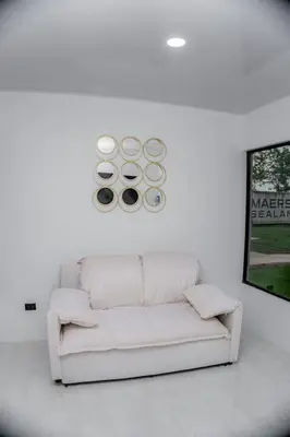 a white couch in a white room with a painting at Villa Sundrop Villa for 8 with Volcano Views & Family Comfort in Fortuna