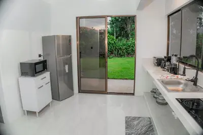 a white kitchen with a sink and a refrigerator at Villa Sundrop Villa for 8 with Volcano Views & Family Comfort in Fortuna