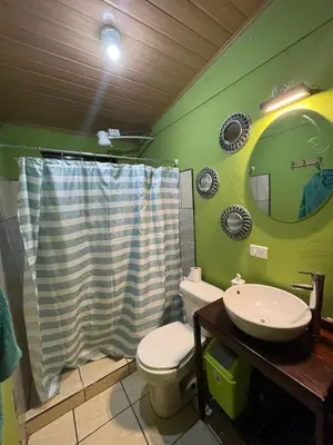a bathroom with a toilet and a sink and a mirror at Apartamento Norte y Sur in Monteverde Costa Rica