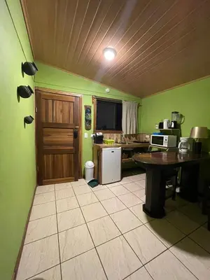 a kitchen with green walls and a table in a room at Apartamento Norte y Sur in Monteverde Costa Rica