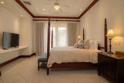 a bedroom with a large bed and a television at Bella Vista 1C 3 bdrs garden view in Los Suenos in Herradura