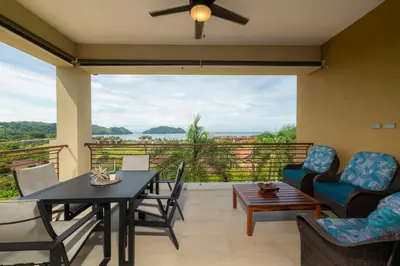 a living room with a table and chairs and a balcony at Miramar 3B 3 bdr Ocean View in Los Suenos in Herradura