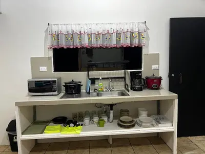 a kitchen counter with a sink and a microwave at Apartamento el Bosque in Nicoya