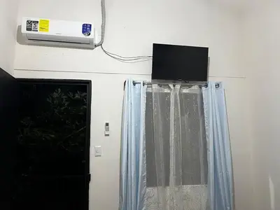 a room with a window with a television on the wall at Apartamento el Bosque in Nicoya