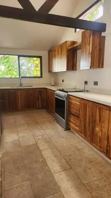 a kitchen with wooden cabinets and a stove at Casa Descanso del Pescador in Garza