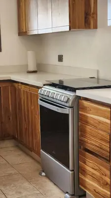 a kitchen with a stove and wooden cabinets at Casa Descanso del Pescador in Garza