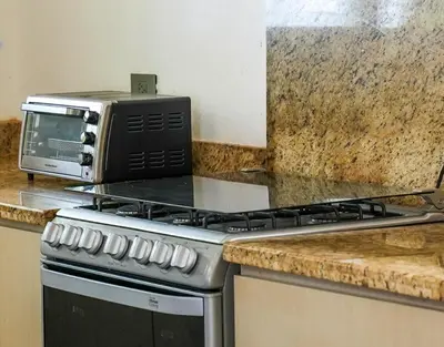 a microwave sitting on top of a stove in a kitchen at Casa Descanso del Pescador in Garza