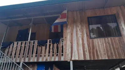 a building with a flag on the side of it at Hospedaje oye in Herradura