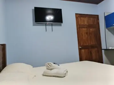a bedroom with a bed with a tv on the wall at Yamis home in General Viejo