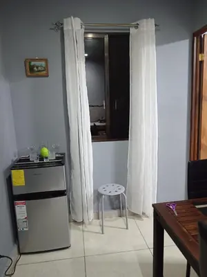 a kitchen with a refrigerator and a stool in a room at Yamis home in General Viejo