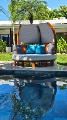 a couch sitting next to a swimming pool at Los Papyrus in Uvita