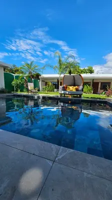 a swimming pool with a chair sitting in front of a house at Los Papyrus in Uvita