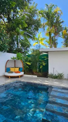 a pool with a chair next to a house at Los Papyrus in Uvita