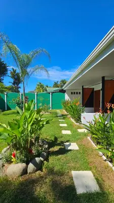 a garden with plants and a building at Los Papyrus in Uvita
