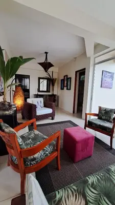 a living room filled with furniture and a pink ottoman at La Miraje Villa in Quepos