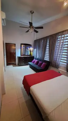 a bedroom with a large bed and a couch at La Miraje Villa in Quepos