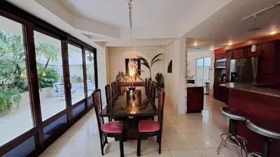 a dining room with a table and a kitchen at La Miraje Villa in Quepos