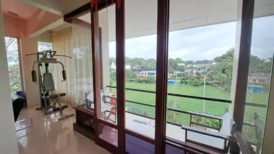 a room with a large window with a view of a field at La Miraje Villa in Quepos
