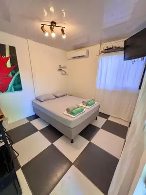a small bedroom with a bed and a checkered floor at Perla Dreamy Cabin with Private Pool in Paraíso
