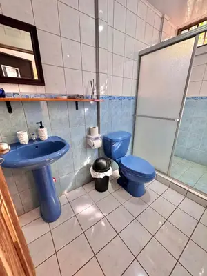 a bathroom with a blue toilet and a sink at Perla Dreamy Cabin with Private Pool in Paraíso