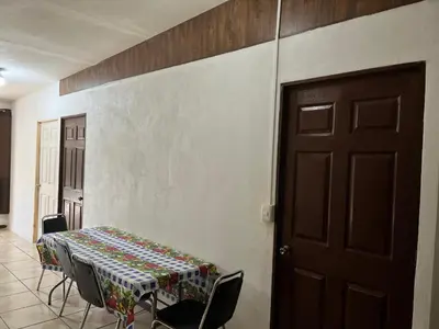 a room with a table and chairs and a door at Sleep&Go! Apartamento de 3 habitaciones in Siquirres