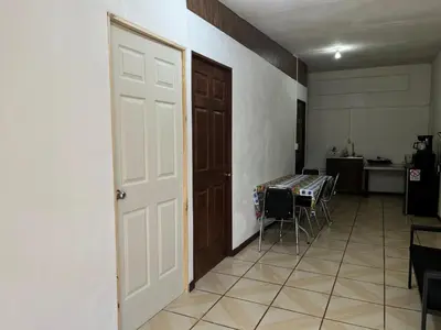 a room with a door and a table and a kitchen at Sleep&Go! Apartamento de 3 habitaciones in Siquirres