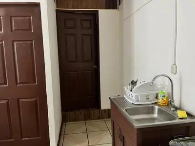 a kitchen with a sink and a brown door at Sleep&Go! Apartamento de 3 habitaciones in Siquirres