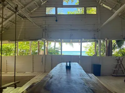 a large room with a wooden floor and windows at Casa de Artistas in Playa Pelada