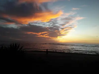 a person standing on the beach at sunset at Casa de Artistas in Playa Pelada