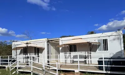 a white trailer with two chairs and an umbrella at Cabinas Diana in San José Pinilla
