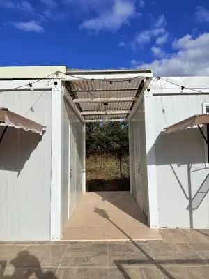 an open door to a white building with a fence at Cabinas Diana in San José Pinilla